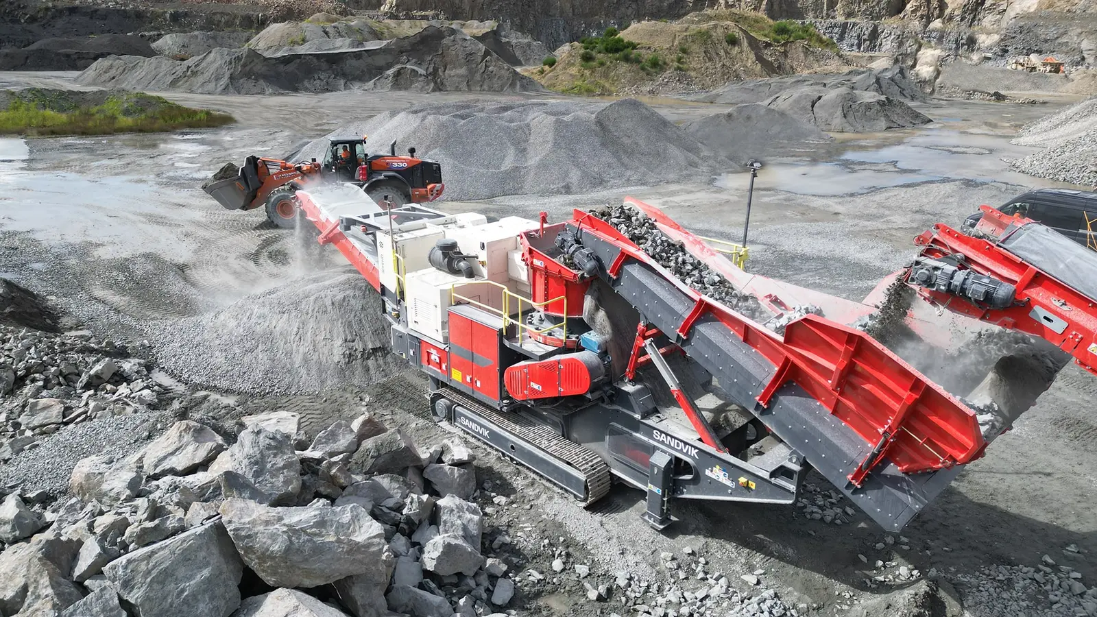 Real Sandvik QH443E tracked mobile cone crusher operating in a hard-rock quarry